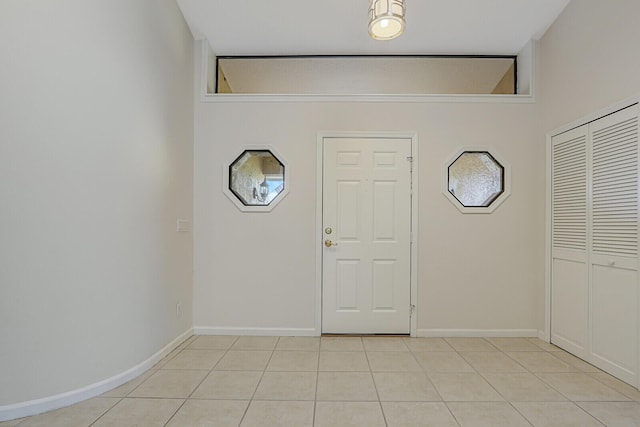 foyer entrance with baseboards and light tile patterned floors