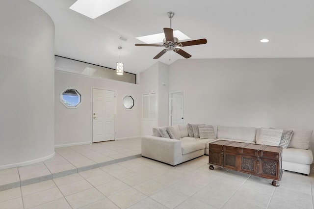 living room with baseboards, high vaulted ceiling, a ceiling fan, light tile patterned floors, and a skylight