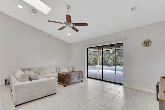 living room with visible vents, lofted ceiling with skylight, baseboards, and ceiling fan