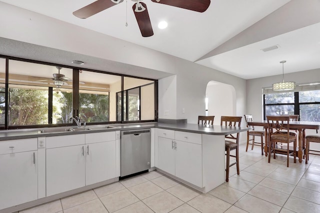 kitchen with arched walkways, ceiling fan, dishwasher, and dark countertops