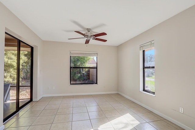 spare room with plenty of natural light, a ceiling fan, baseboards, and light tile patterned floors