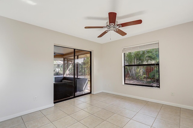 spare room with a ceiling fan, baseboards, and light tile patterned floors