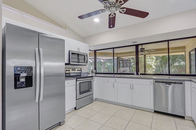 kitchen featuring lofted ceiling, ceiling fan, white cabinetry, light tile patterned flooring, and stainless steel appliances