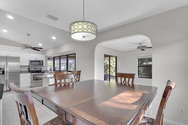 dining area with a ceiling fan, arched walkways, visible vents, and a wealth of natural light