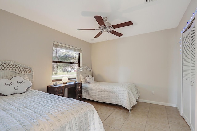 bedroom with a ceiling fan, baseboards, tile patterned flooring, and a closet