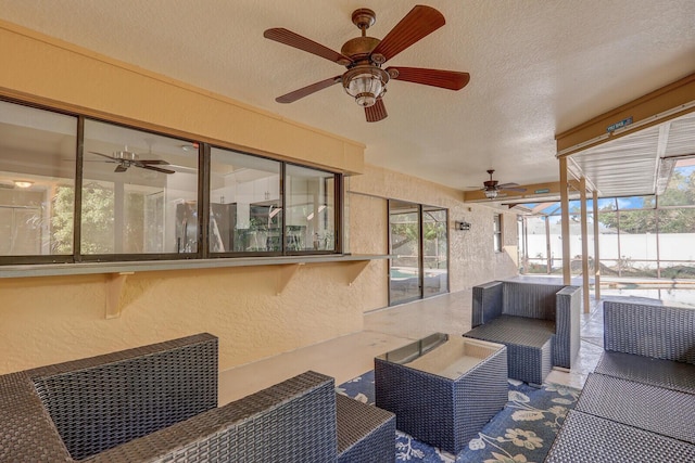 sunroom featuring ceiling fan, outdoor lounge area, and a healthy amount of sunlight