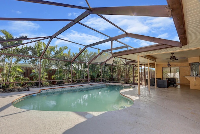 pool with a patio, a ceiling fan, and glass enclosure