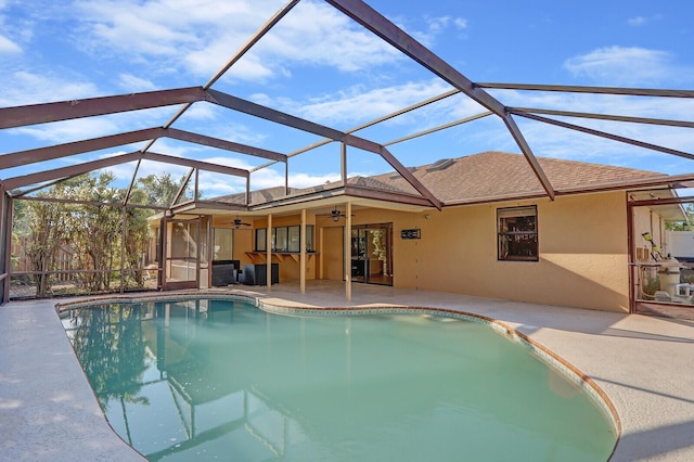outdoor pool featuring a ceiling fan, a patio, and glass enclosure