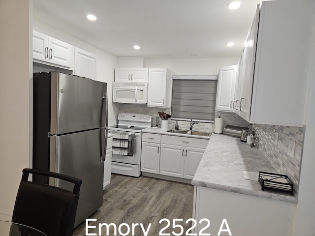 kitchen with white appliances, sink, and white cabinets