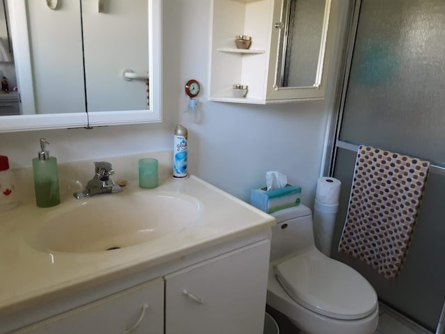 bathroom featuring vanity, toilet, and an enclosed shower