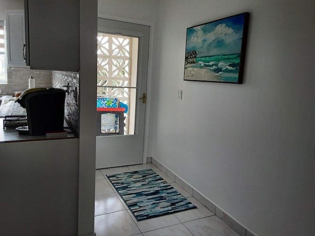 doorway with light tile patterned floors