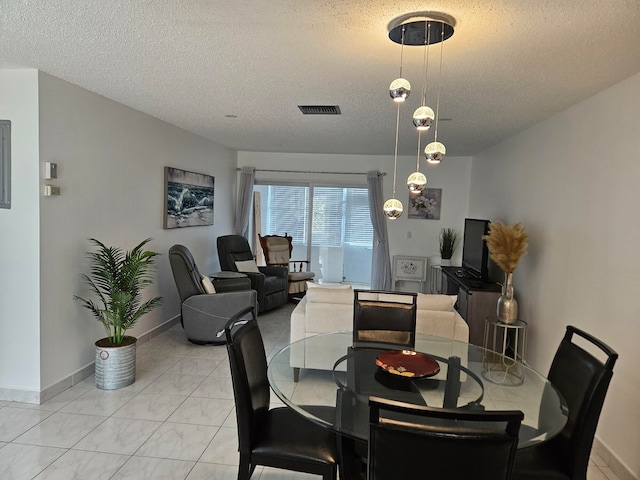 tiled dining area with a textured ceiling