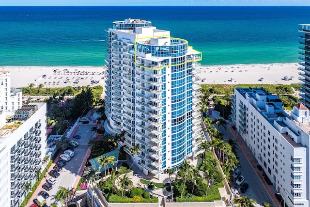 drone / aerial view featuring a water view and a view of the beach