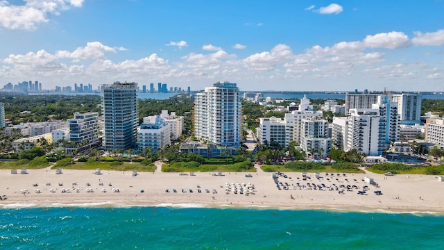 birds eye view of property with a water view and a beach view