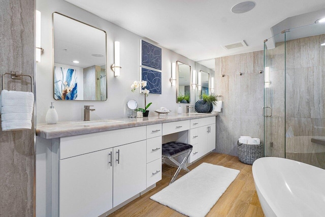 bathroom with vanity, tile walls, hardwood / wood-style floors, and walk in shower