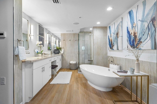 bathroom featuring hardwood / wood-style flooring, vanity, and independent shower and bath