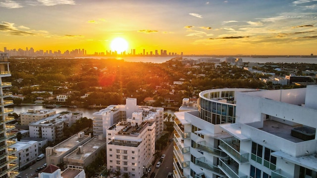 aerial view at dusk featuring a water view