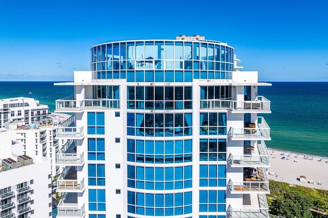 view of building exterior featuring a water view and a view of the beach