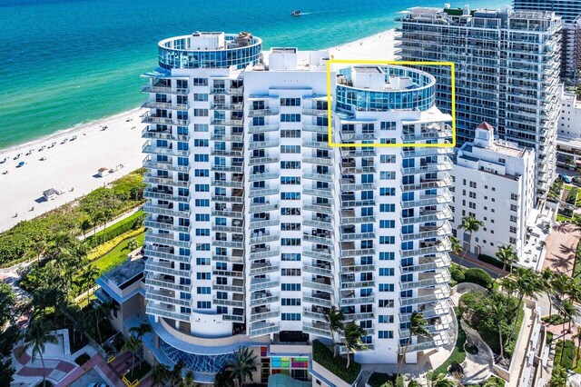 drone / aerial view with a water view and a view of the beach