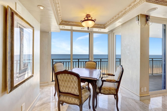 sunroom featuring a tray ceiling, a water view, and visible vents