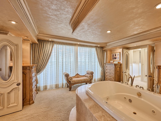 bathroom with a textured ceiling, vanity, tiled tub, and crown molding