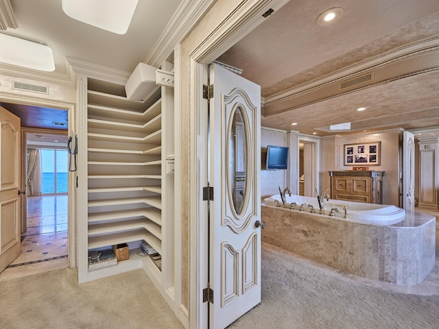 bathroom with a tub to relax in, a water view, and ornamental molding