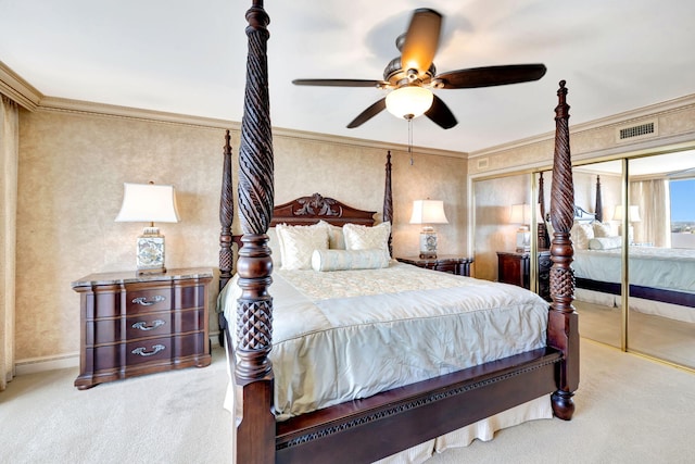 bedroom with baseboards, visible vents, carpet, crown molding, and multiple closets