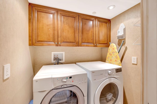 washroom with washing machine and dryer and cabinet space