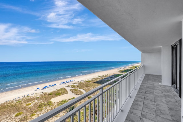 balcony with a water view and a beach view