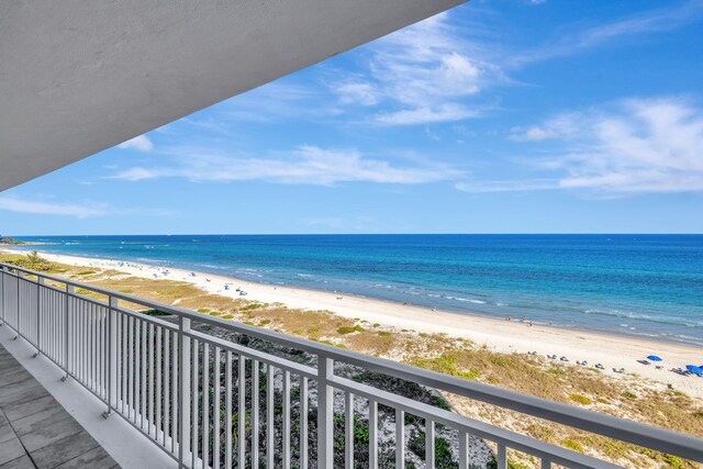 balcony featuring a water view and a beach view