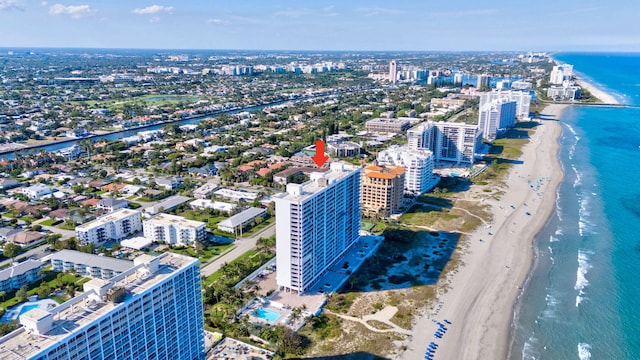 drone / aerial view with a water view, a city view, and a view of the beach