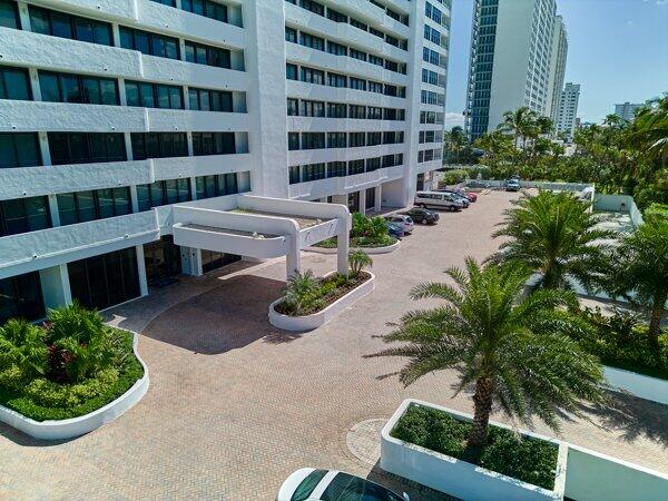 view of property with uncovered parking and a city view