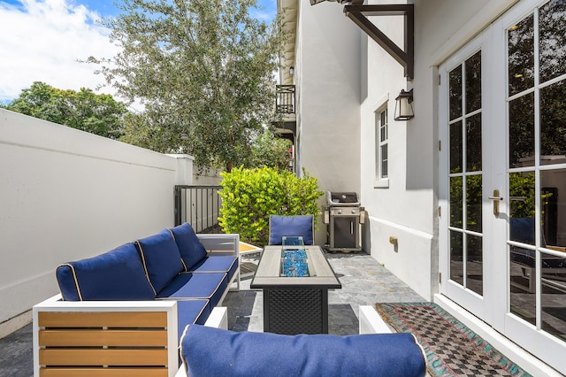 view of patio with french doors, an outdoor living space with a fire pit, and grilling area