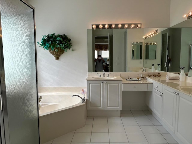 bathroom with a tub, vanity, and tile patterned floors