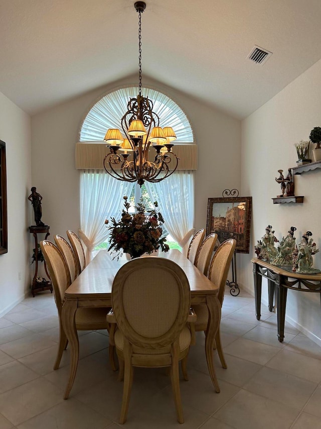 tiled dining space featuring a notable chandelier and lofted ceiling