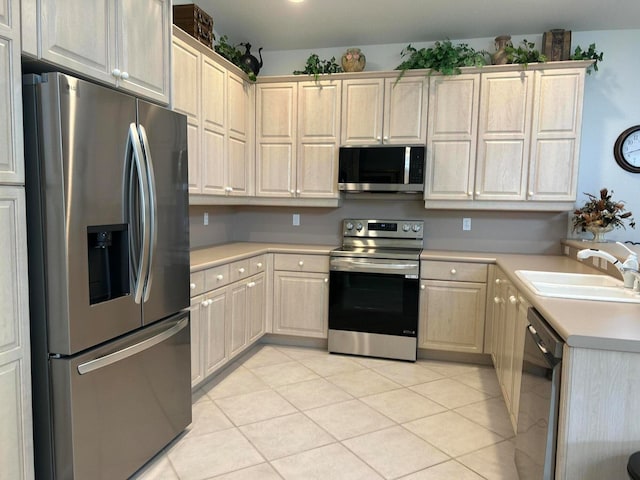 kitchen featuring appliances with stainless steel finishes, sink, and light tile patterned flooring