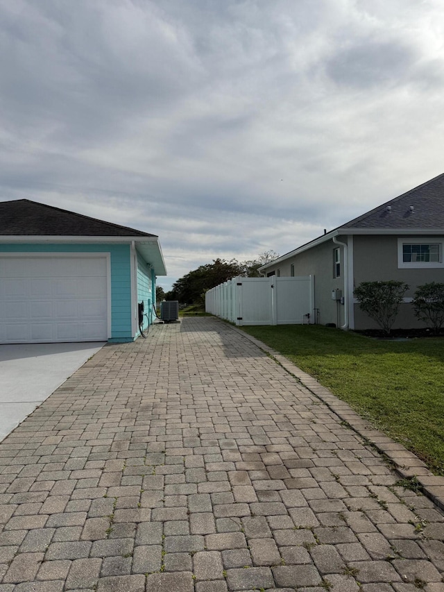 view of home's exterior with central AC unit and a yard