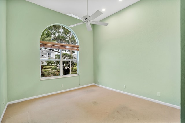 unfurnished room with a high ceiling, ceiling fan, and carpet floors