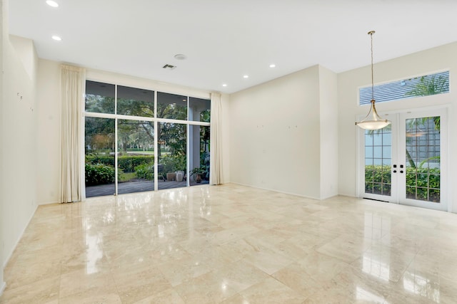 empty room featuring french doors and expansive windows