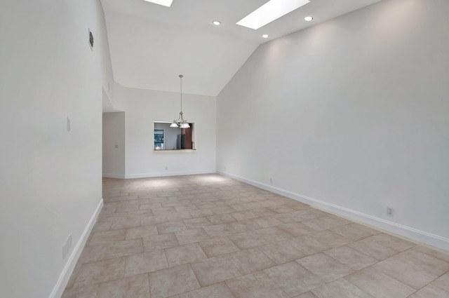 unfurnished living room featuring high vaulted ceiling, a skylight, and an inviting chandelier