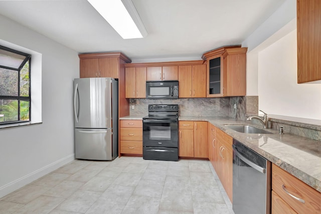 kitchen featuring black appliances, sink, and backsplash