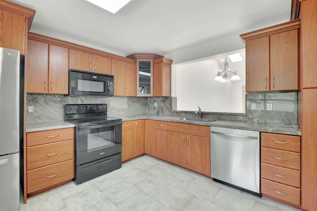 kitchen with sink, black appliances, decorative light fixtures, a chandelier, and tasteful backsplash