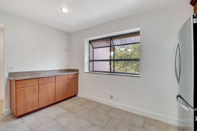 kitchen featuring stainless steel fridge and light tile patterned floors