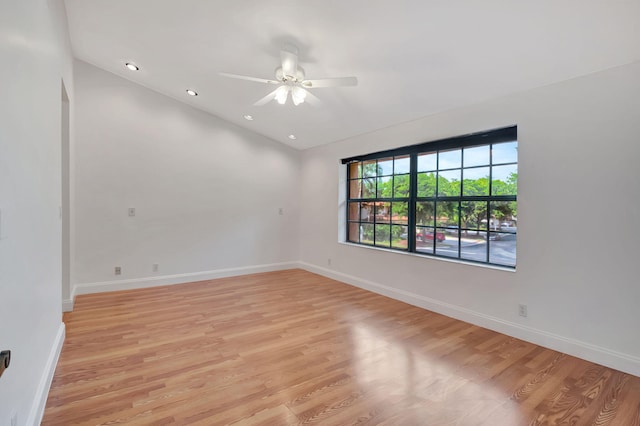 empty room with vaulted ceiling, light wood-type flooring, and ceiling fan