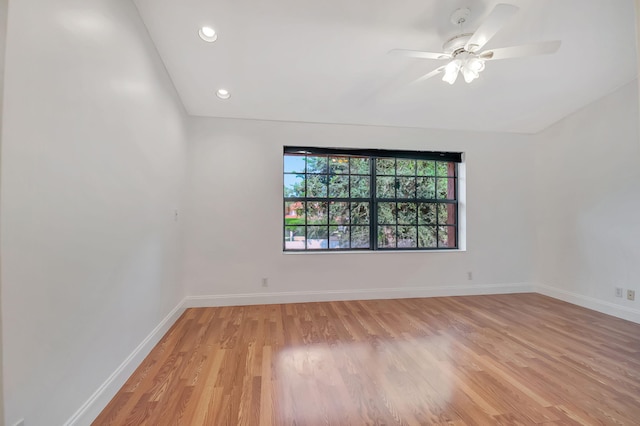 empty room featuring vaulted ceiling, light wood-type flooring, and ceiling fan