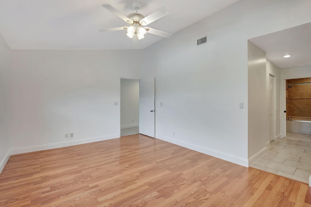 empty room with light hardwood / wood-style floors, lofted ceiling, and ceiling fan