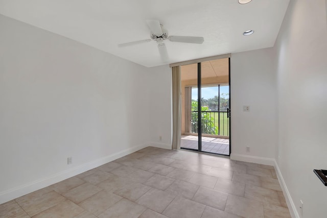 unfurnished room with floor to ceiling windows, light tile patterned floors, and ceiling fan