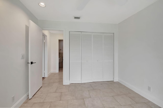 unfurnished bedroom with a closet and light tile patterned floors