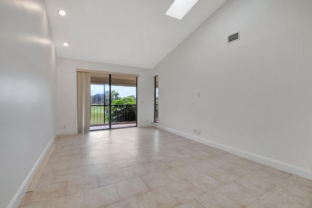 spare room with high vaulted ceiling and a skylight