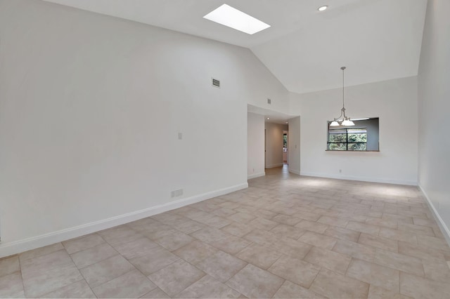 unfurnished room with a notable chandelier and high vaulted ceiling